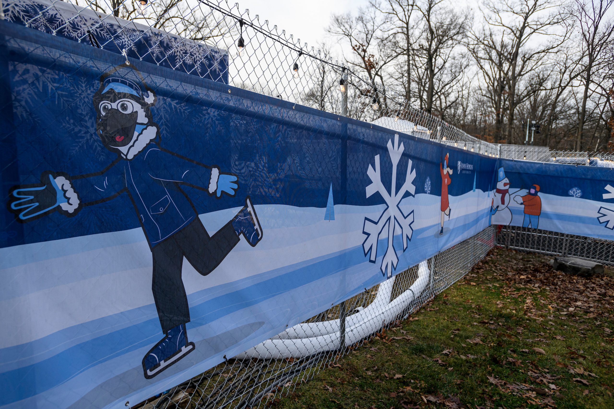 Fence skrim featuring an ice skating Jay, the mascot