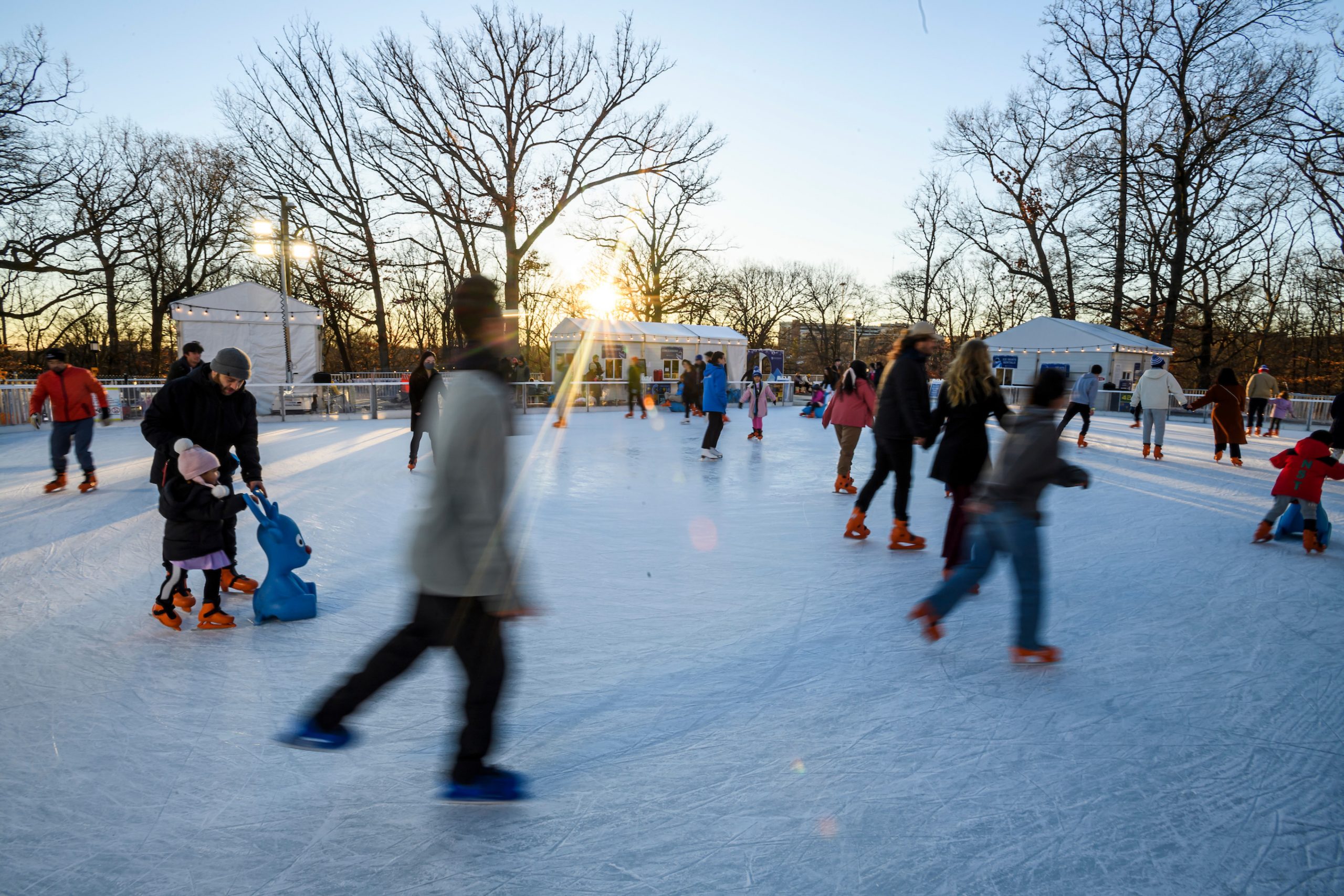 Skaters on the ice rink at sunset